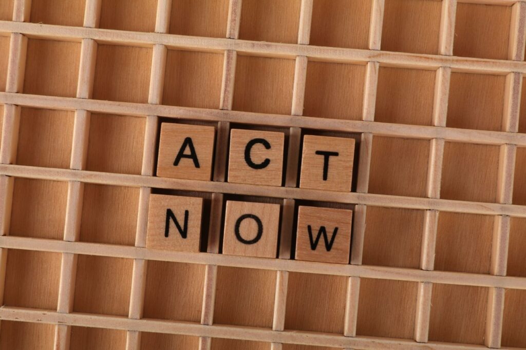 Wooden Scrabble letters spelling 'Act Now' on a grid, inspiring immediate action.